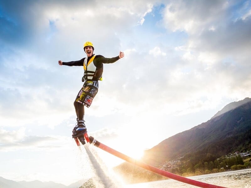 Un homme pratiquant le flyboard au coucher du soleil