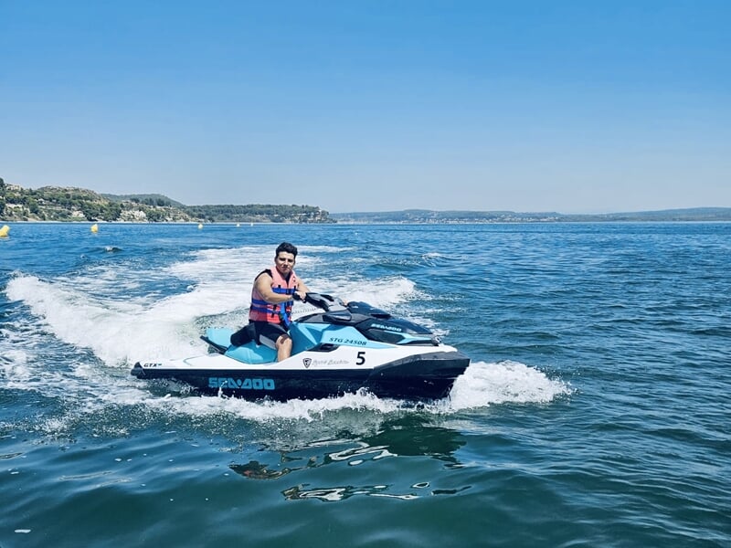 Un homme faisant du jet-ski avec la côte en arrière-plan