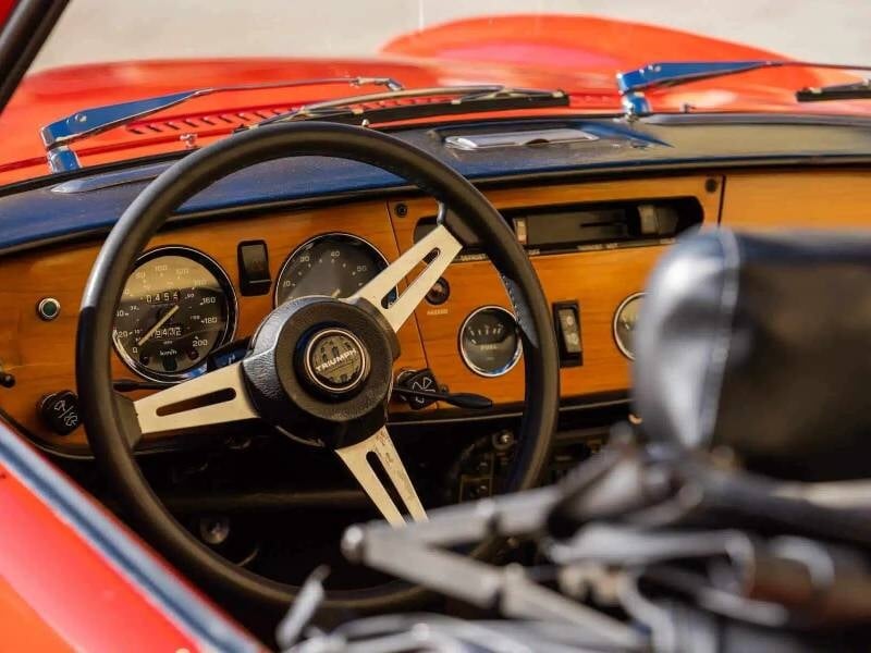 Un tableau de bord détaillé d’un modèle vintage, avec des cadrans analogiques, des interrupteurs classiques et une ambiance rétro authentique.