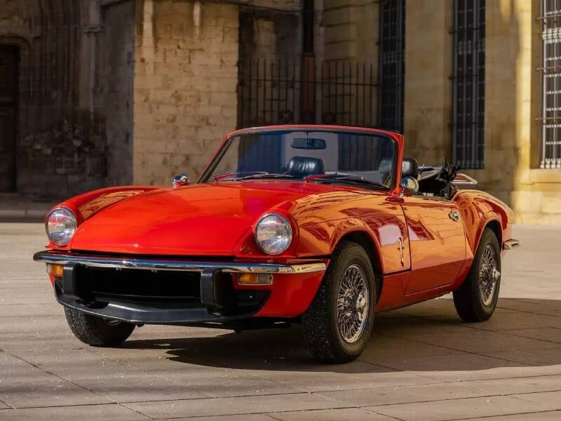 Une voiture de collection vue de face, avec une calandre caractéristique et un design compact mais dynamique. Son style rappelle les voitures de sport britanniques.