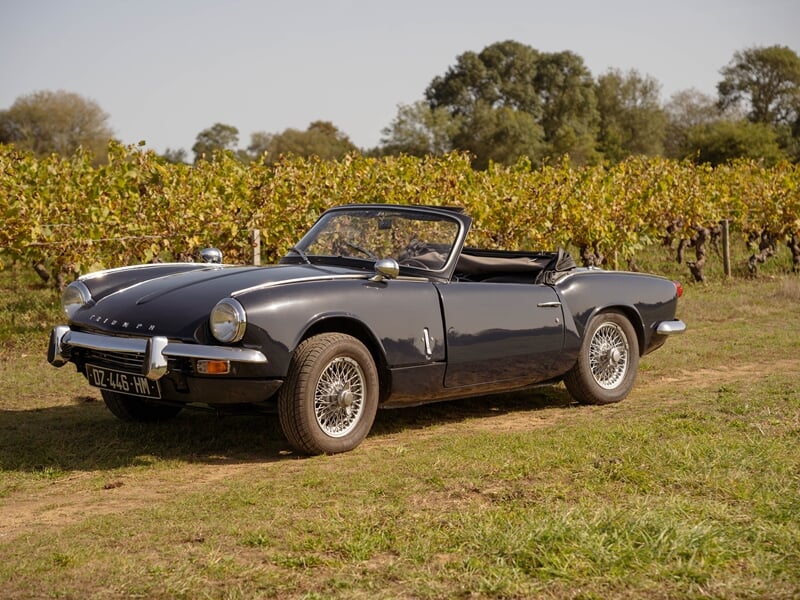 Triumph Spitfire devant des vignes