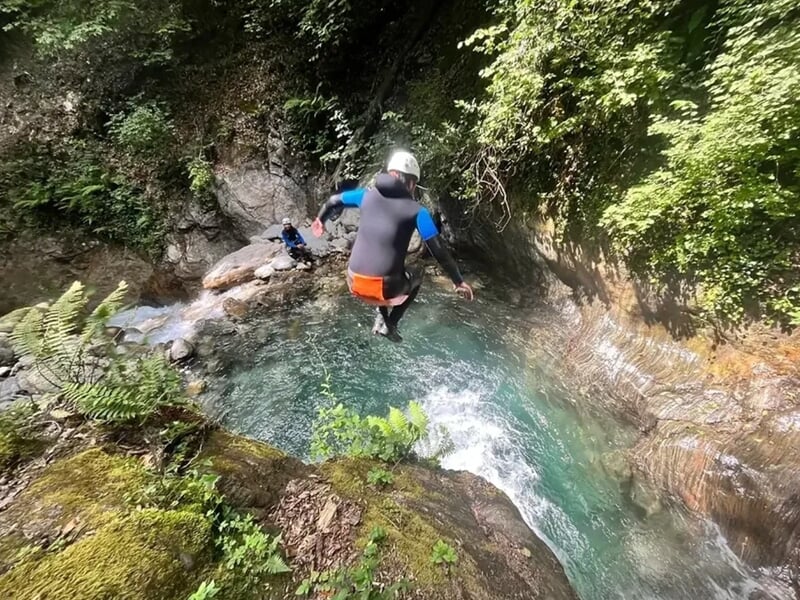 Personne pratiquant le canyoning et faisant un saut dans l'eau
