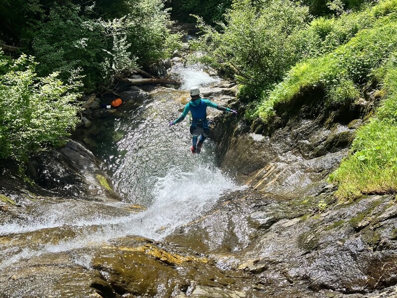 Personne pratiquant le canyoning et faisant un saut dans l'eau