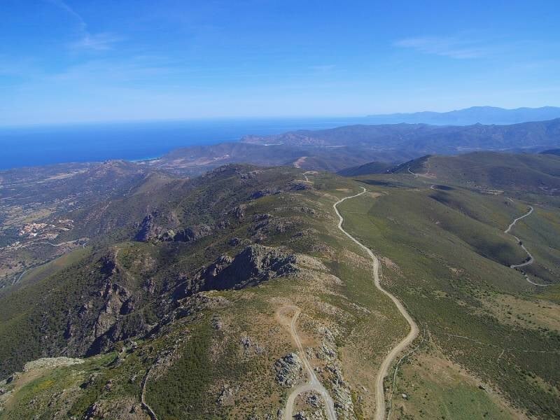Vue aérienne d'une route à flanc de crète avec la mer au loin