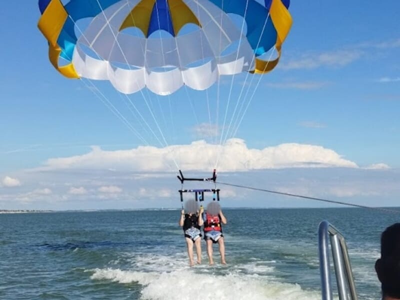 Deux personnes faisant du parachute ascensionnel au dessus de la mer