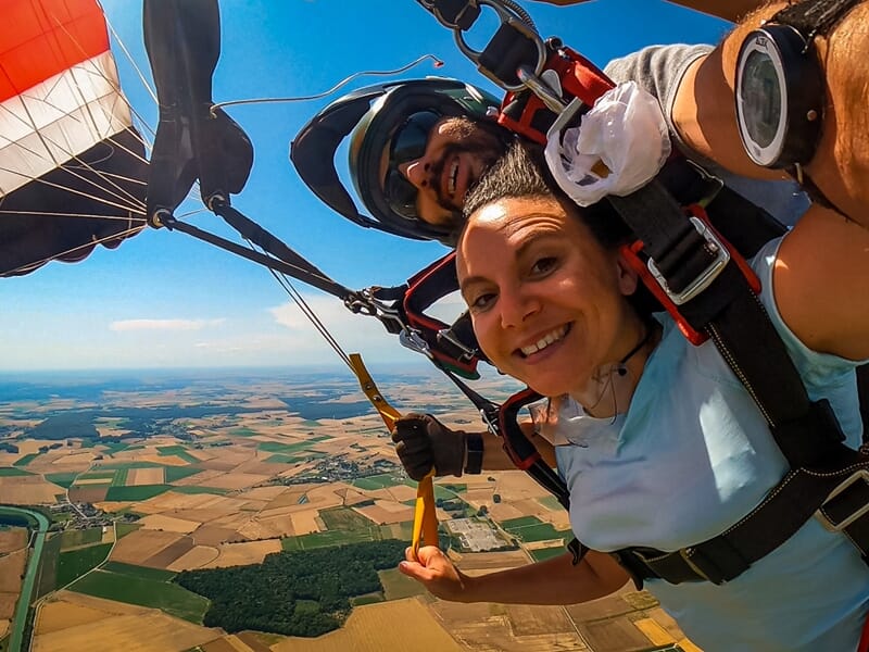 Deux personnes en train de sauter en parachute en tandem avec paysages de l'Oise en fond