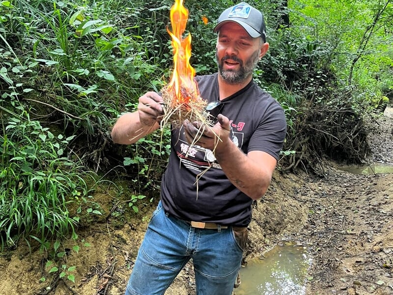 Homme faisant une démonstration en forêt de comment faire du feu