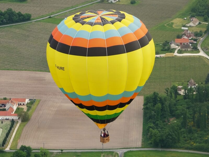 Une montgolfière volant au dessus des champs