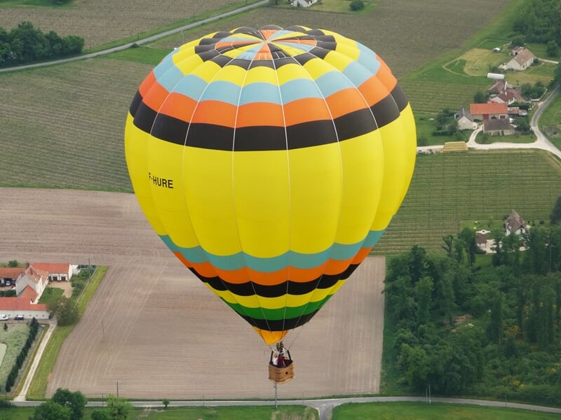 Une montgolfière volant au dessus des champs