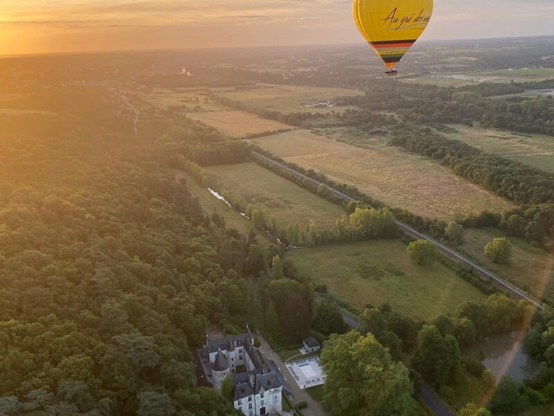 Une montgolfière au soleil couchant au dessus de la campagne