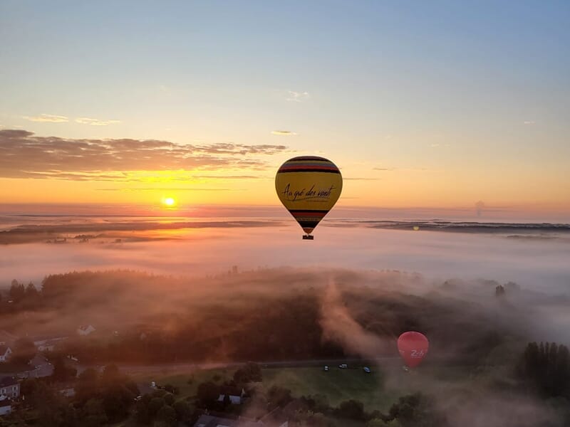 Une montgolfière au soleil couchant au dessus de la campagne