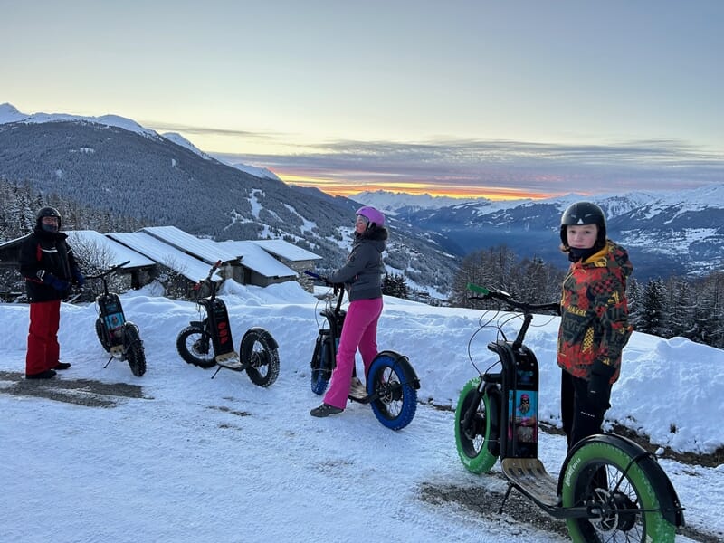 Groupe de 3 personnes en trottinette électrique à la montagne sur la neige