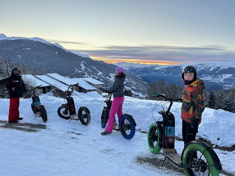 Groupe de 3 personnes en trottinette électrique à la montagne sur la neige