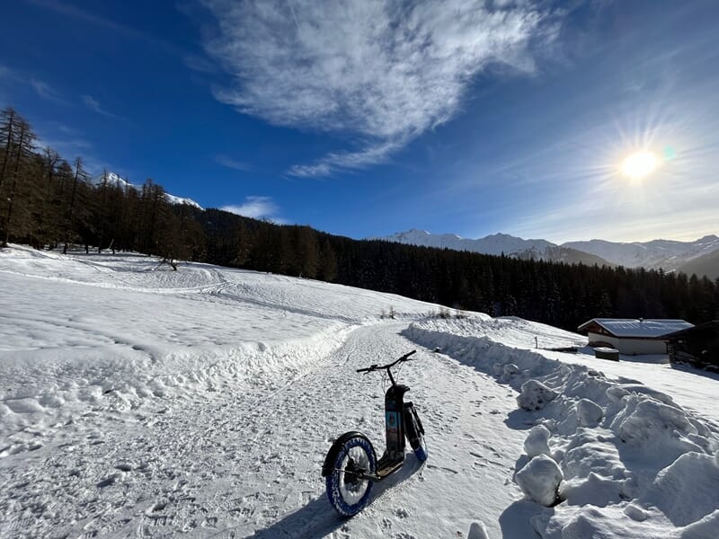 Trottinette électrique sur la neige avec ciel bleu