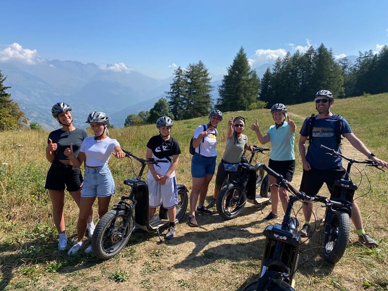 Groupe de personnes pratiquant la trottinette électrique en montagne