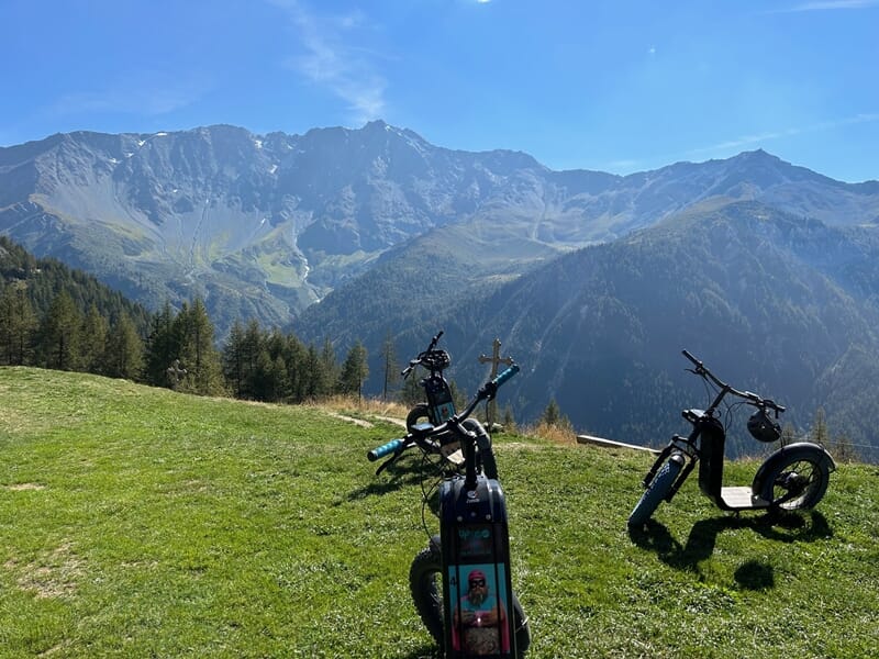 Trottinettes électriques devant un paysage de montagne