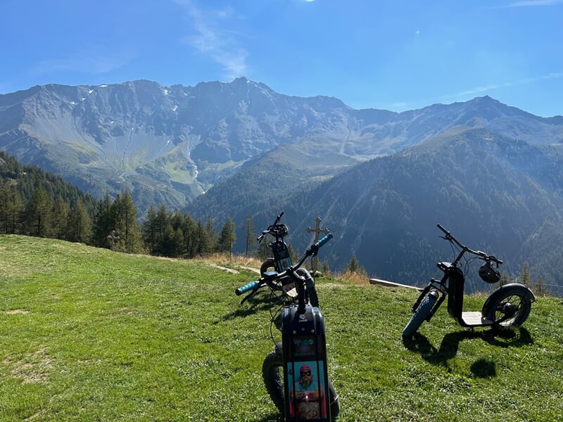 Trottinettes électriques devant un paysage de montagne