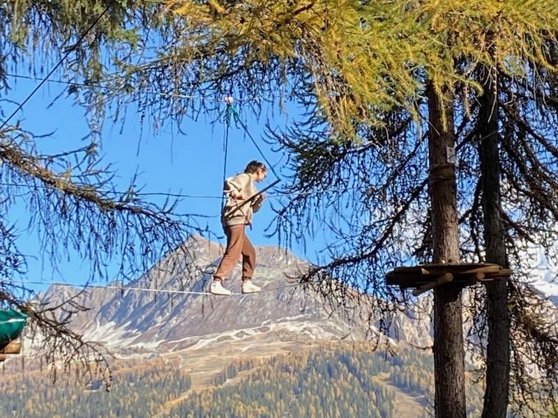 Une femme effectuant un parcours d'accrobranche dans les arbres
