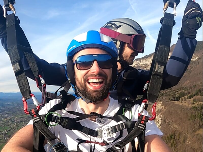 Selfie de deux personnes pratiquant le parapente en tandem