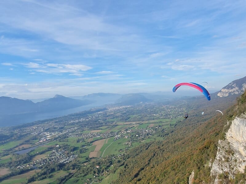 Voile de parapente au loin au dessus des paysages de Savoie