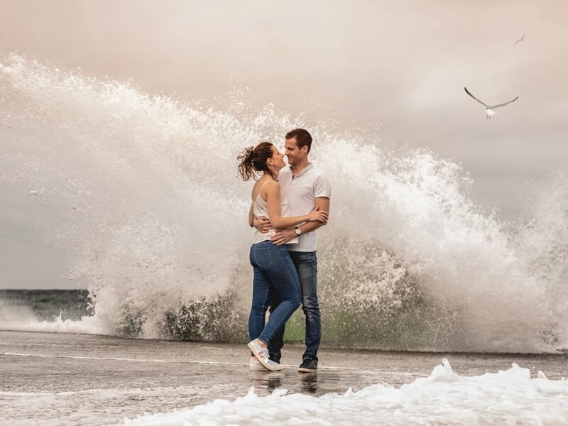 Couple en bord de mer avec mouvement des vagues et mouette en arrière plan