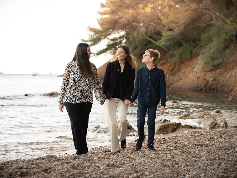 Famille de deux femmes et un adolescent marchant en bord de mer