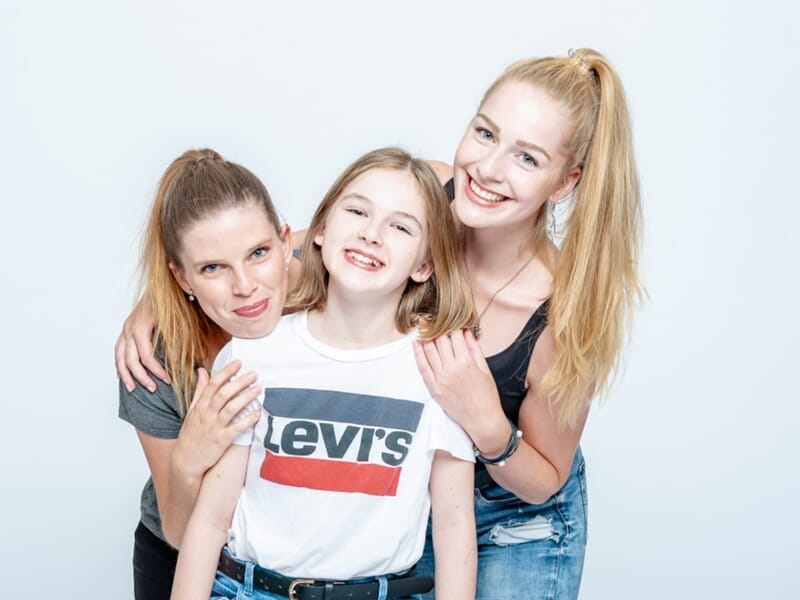 Trois sœurs ou amies souriantes, lien fort et joyeux.