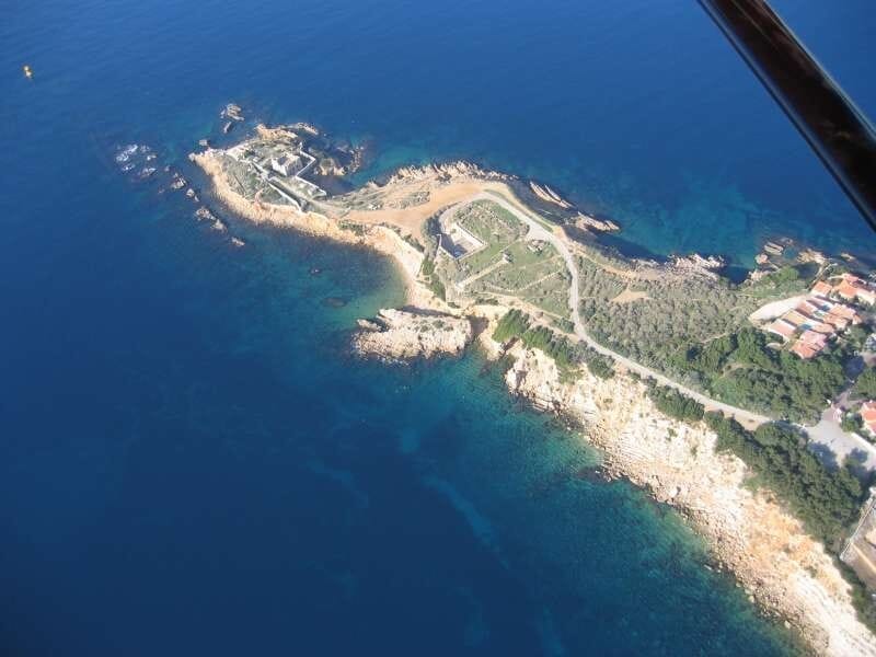 Vue mer depuis les airs, avec un bras de terre jaune et vert