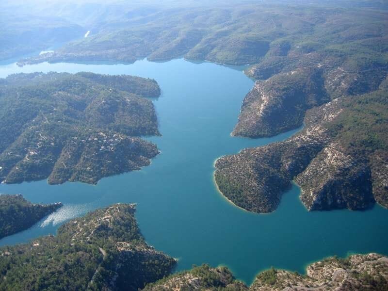 Vue aérienne sur les eaux turquoise du lac d'Esparron, sinueux et entouré de verdure