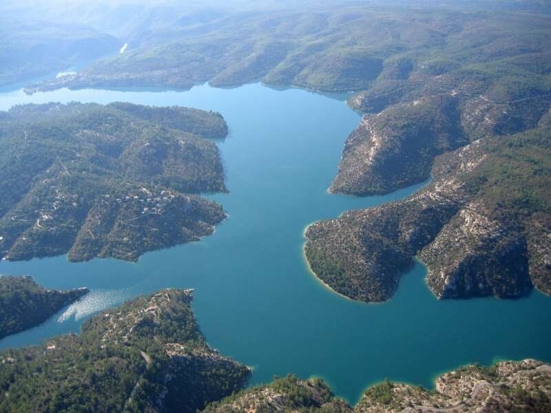 Vue aérienne sur les eaux turquoise du lac d'Esparron, sinueux et entouré de verdure