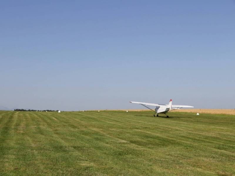 Décollage d'un ULM multiaxes sur un champ d'herbe verte