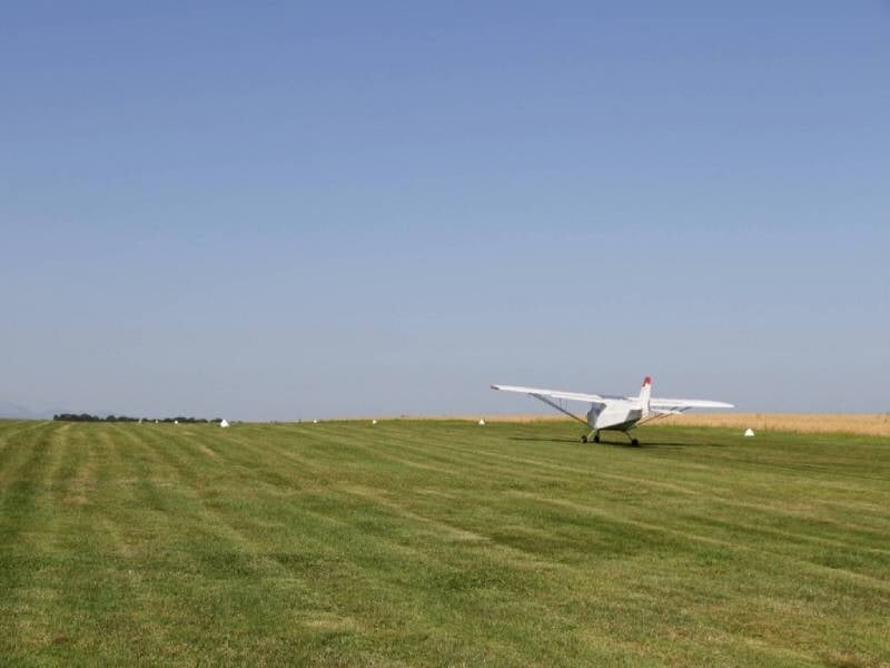 Décollage d'un ULM multiaxes sur un champ d'herbe verte