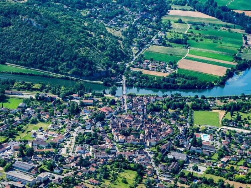 Vue aérienne sur un village typique du Lot, entouré de nature.
