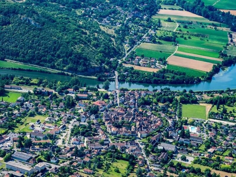Vue aérienne sur un village typique du Lot, entouré de nature.