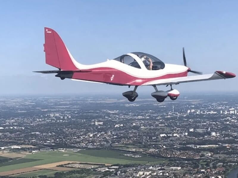 Avion rouge et blanc en vol lors d'un vol en avion ULM à Lens.