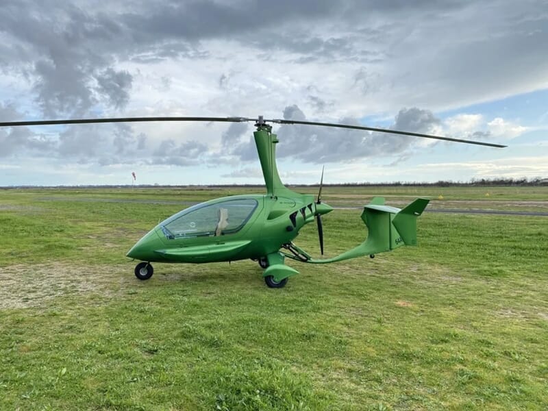 Gyrocoptère vert stationné sur une pelouse verte, lors d'un vol en autogire près d'Oloron-Sainte-Marie.