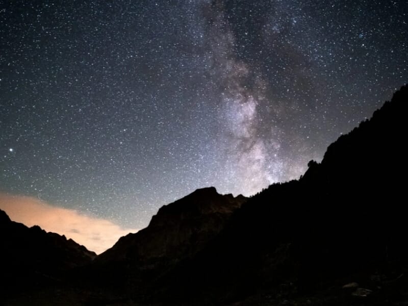 Voie lactée brillante sur fond de montagnes enneigées vues de nuit