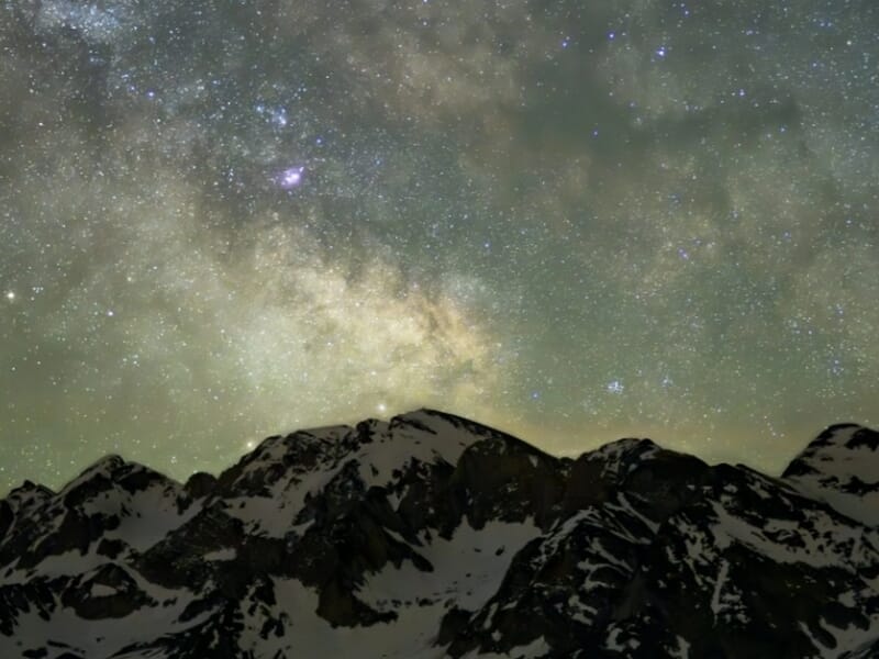 Voie lactée au-dessus de montagnes sombres dans une vallée nocturne