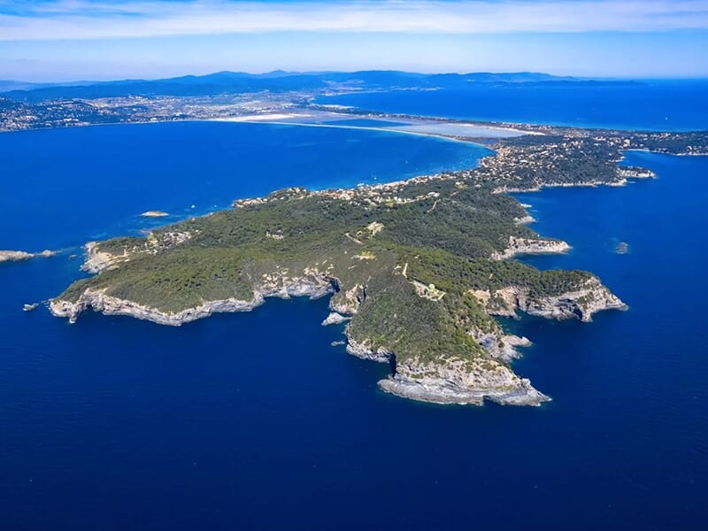 Vue aérienne de la presqu'île de Giens entourée par la mer Méditerranée, avec la côte varoise visible à l’horizon.