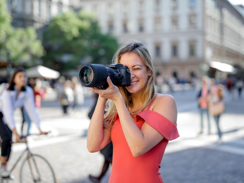 Femme prenant des photos au sein d'une ville