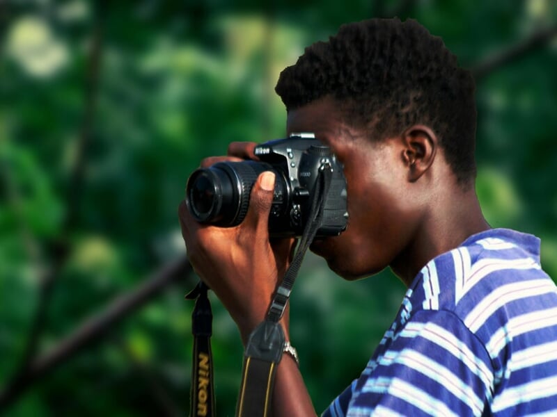 Homme utilisant un appareil photo dans un décor de forêt