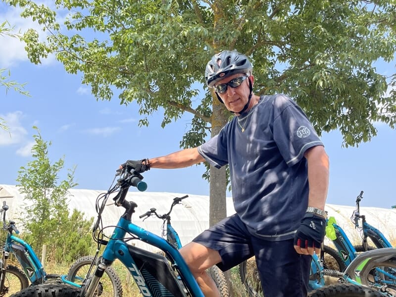 Homme casqué en tenue de sport sur un vélo électrique, prêt pour une balade en pleine nature.