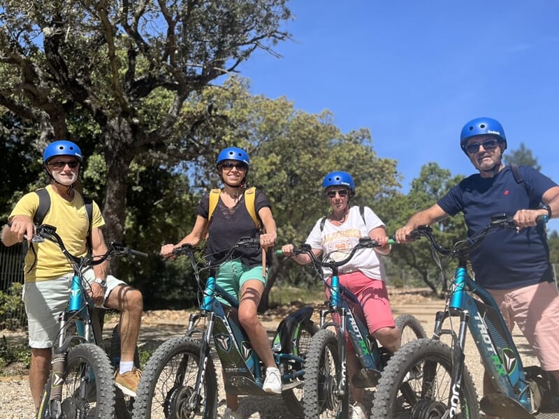 Groupe de quatre adultes souriants sur leurs trottinettes électriques, prêts à partir en balade.