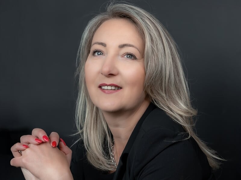 Portrait d'une femme souriante aux cheveux blonds lors d'un shooting avec un photographe de portrait à Lille.