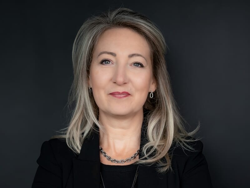 Femme aux cheveux blonds en blazer noir lors d'un shooting avec un photographe de portrait à Lille.