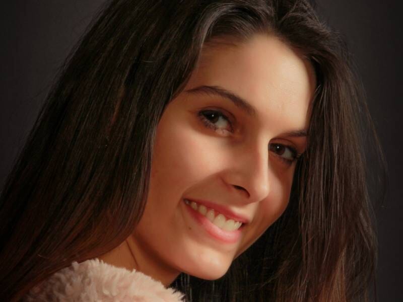 Portrait rapproché d'une jeune femme brune souriante.