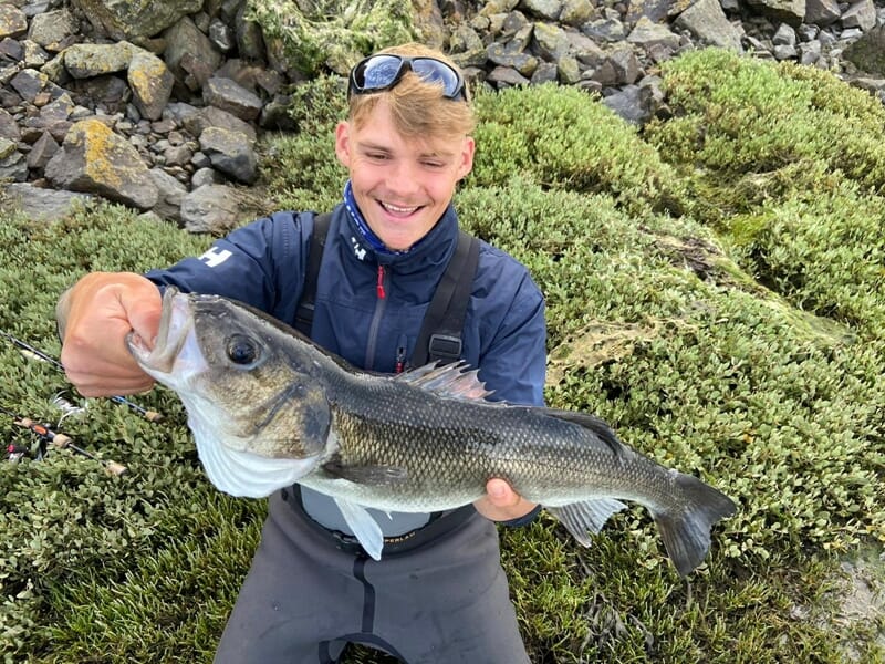 Jeune pêcheur heureux montrant un poisson lors d'un stage de pêche à Lille.