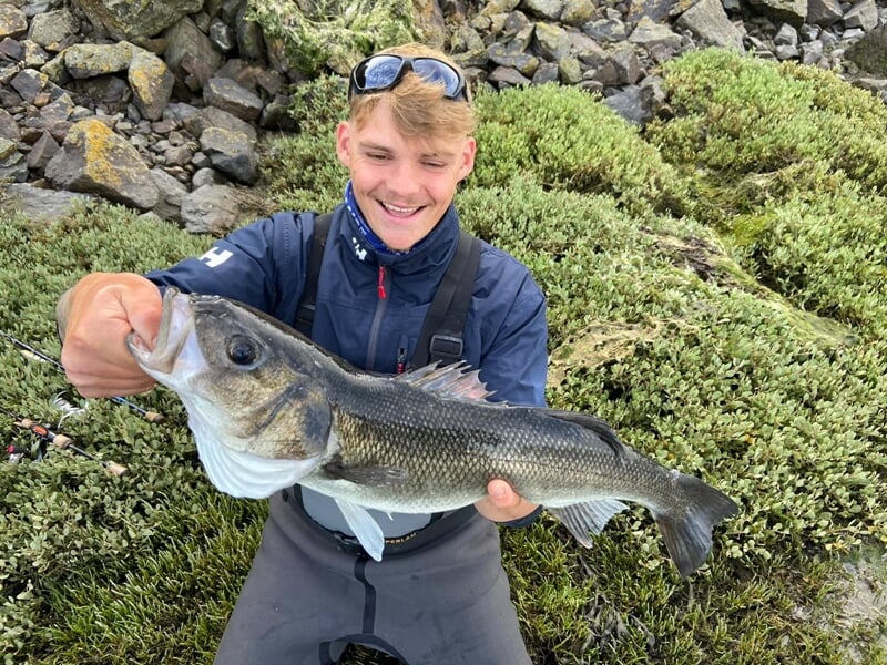 Jeune pêcheur heureux montrant un poisson lors d'un stage de pêche à Lille.