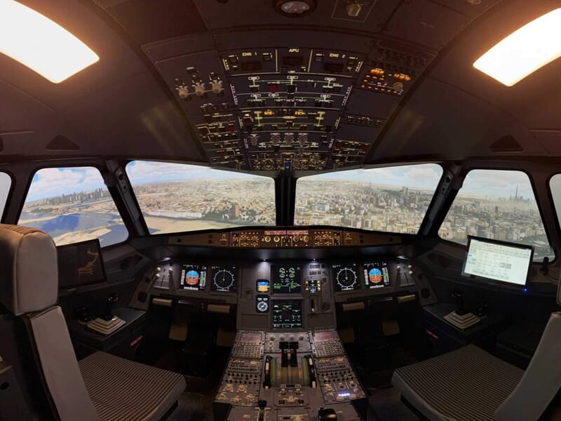 Cockpit d’avion en simulateur de vol avec vue urbaine projetée sur les écrans de pare-brise