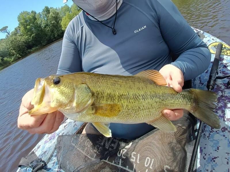 Un homme sur un float tube présente un poisson.